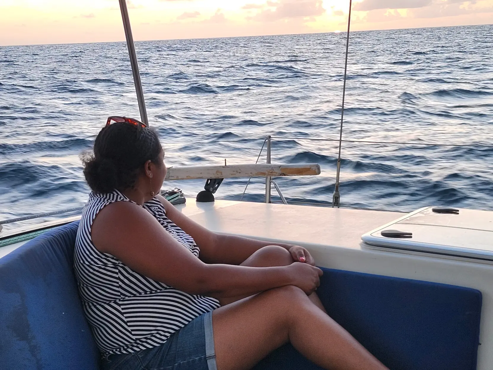 A guest relaxing in the cockpit as Bliss sails into the evening light